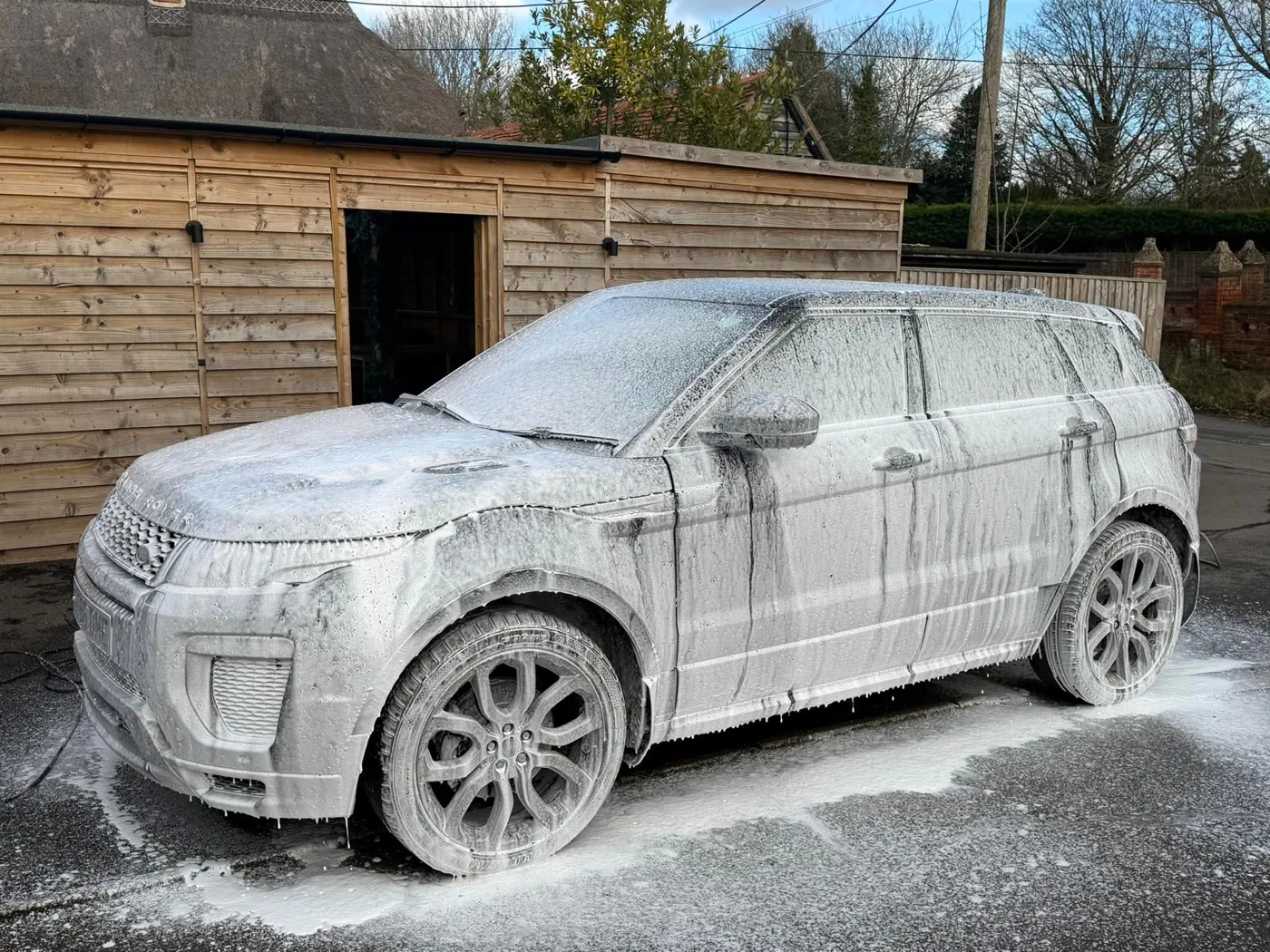 Vehicle covered in snow foam before a safe wash detail